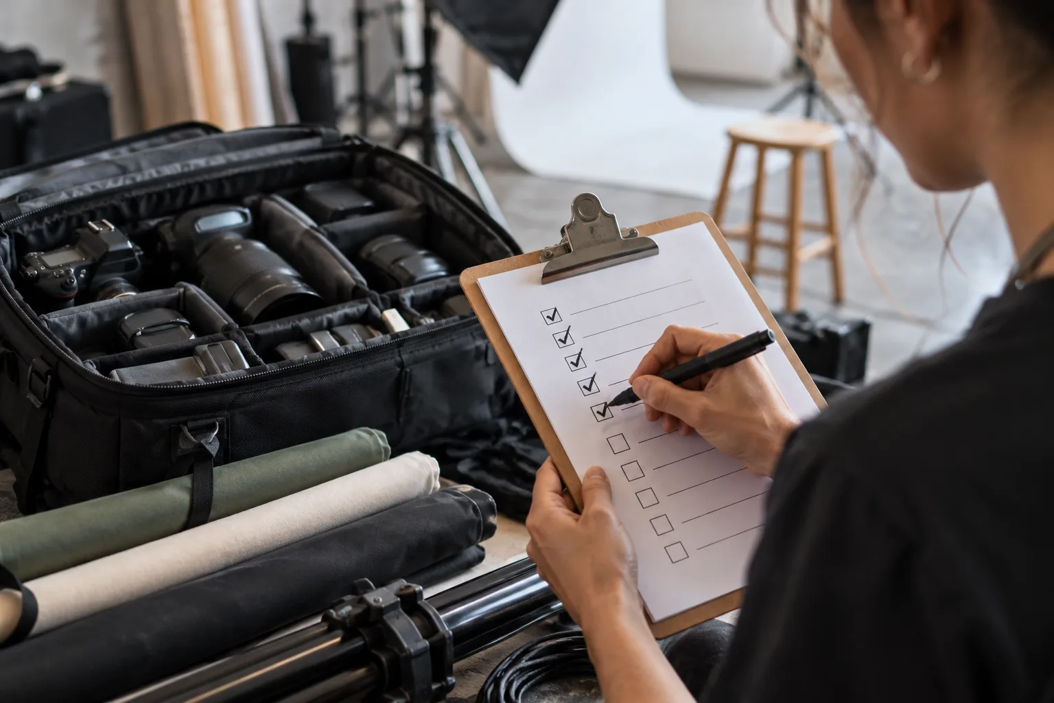 Studio assistant checking tasks beside prepared photography gear
